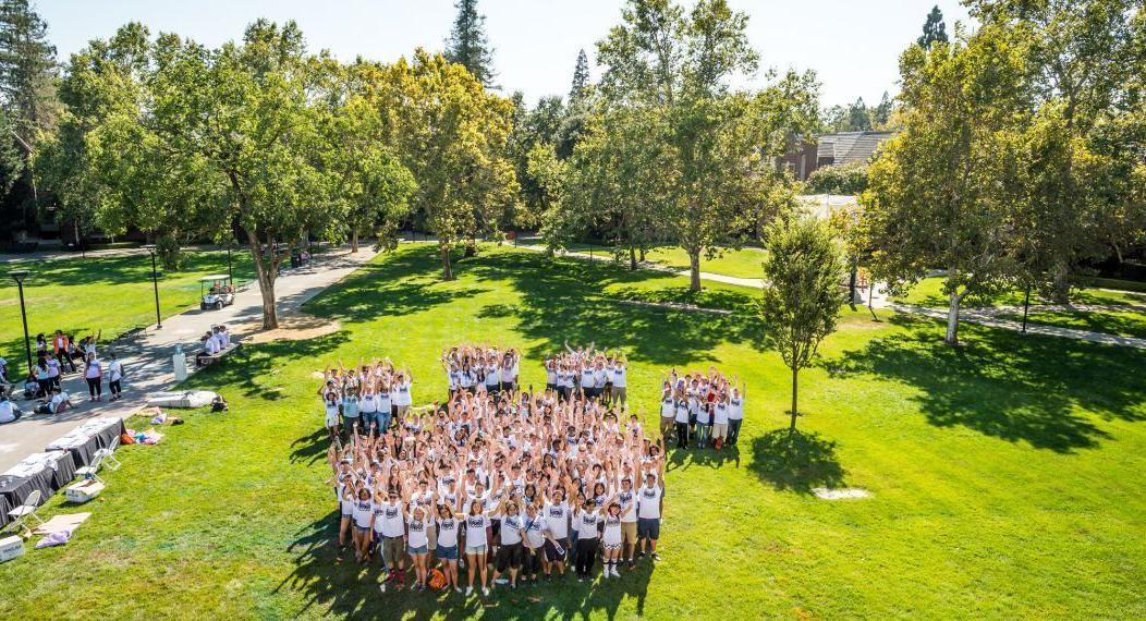 Students standing together in paw print formation